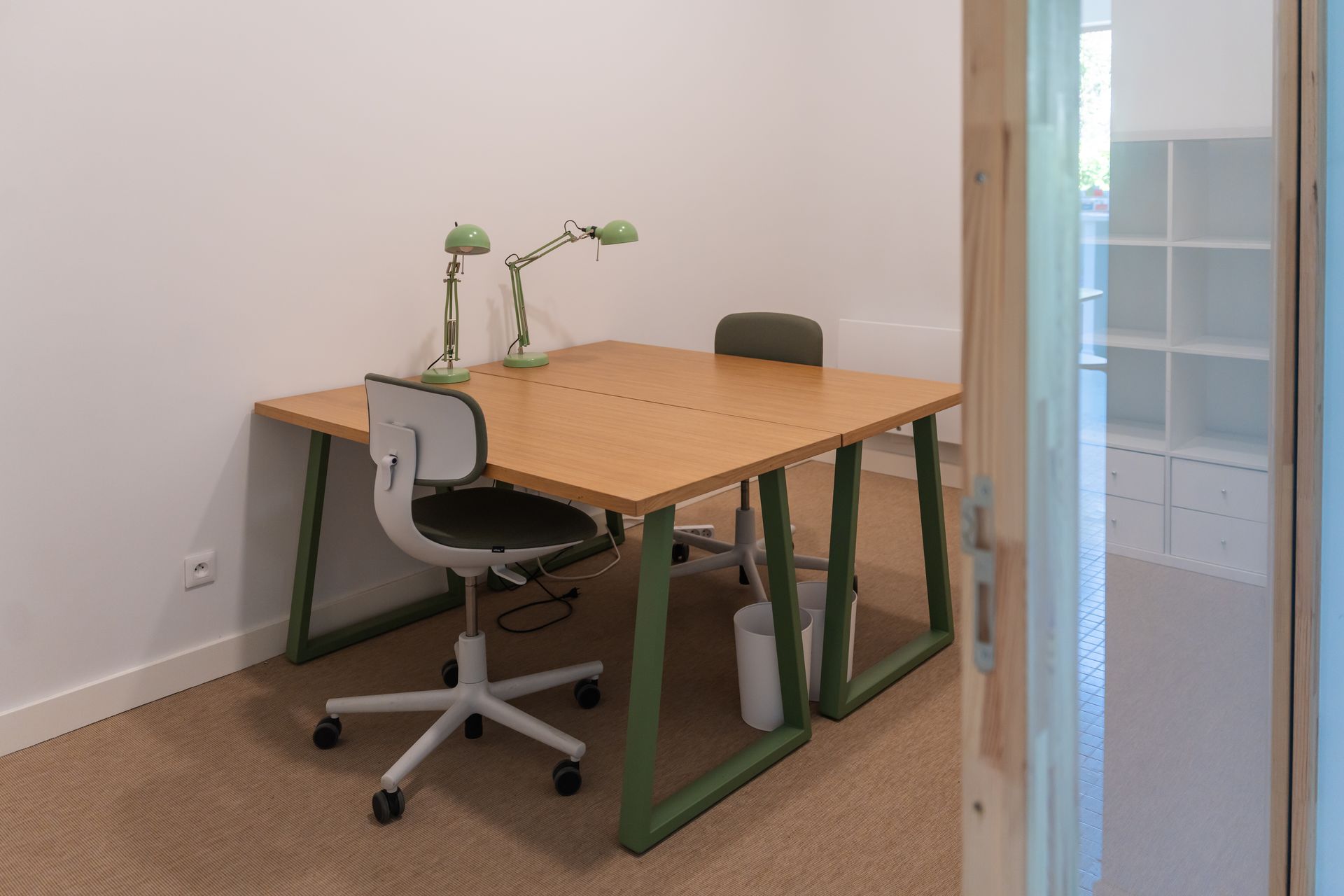 Bureau privé au MIX Café, grande pièce avec deux tables, deux chaises roulantes, deux lampes et des casiers, moquette au sol